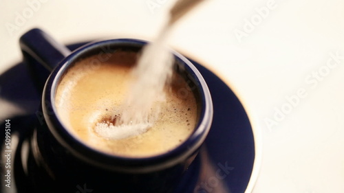 Cup of espresso. Man pours sugar into coffee, stirs and takes it