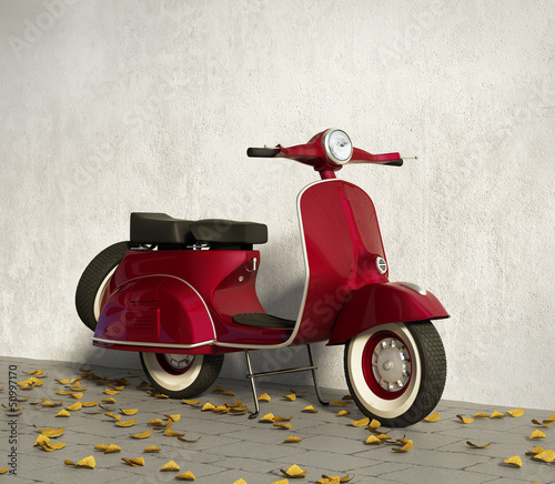 Vintage red motorcycle vespa, by wall with fallen leaves