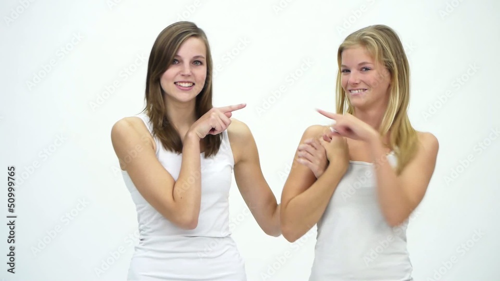 Two Young Girlfriends Against A White Background Two Young Girlfriends Against A White Background