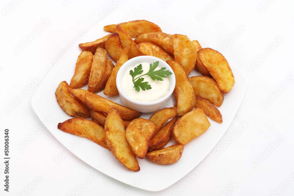 Fried potato wedges with white sauce on white plate Fried potato wedges with white sauce on white plate