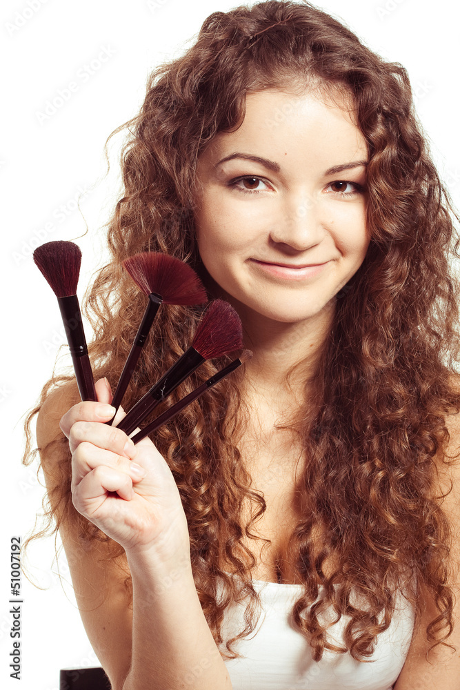 Obraz premium Portrait of young happy smiling woman with make up tools
