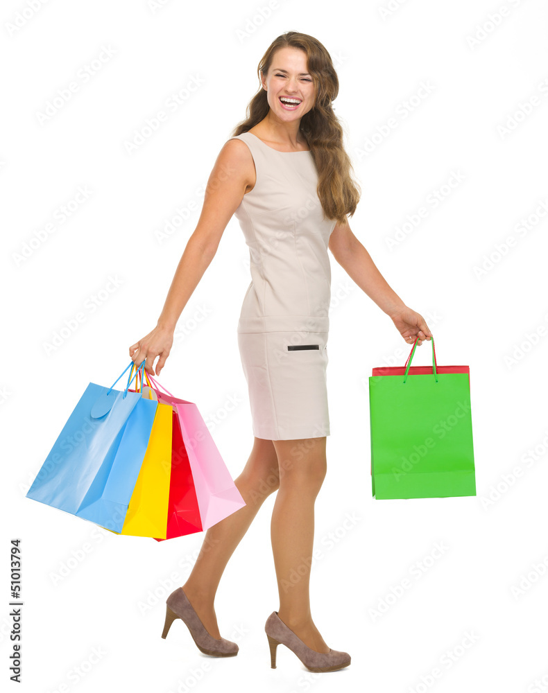 Full length portrait of happy young woman with shopping bags