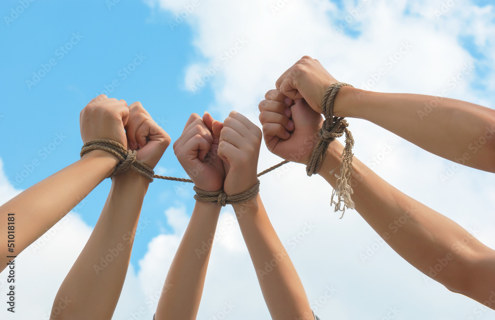 Three pairs of human hands tied up together