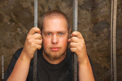 Obraz na płótnie Young man behind the bars w salonie