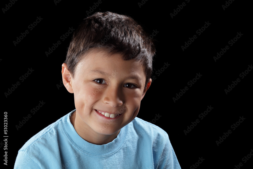 Smiling boy on black background with dramatic side lighting