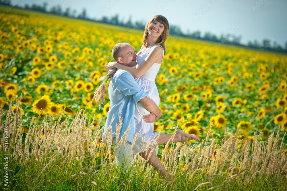 loving young couple in a field of sunflowers loving young couple in a field of sunflowers