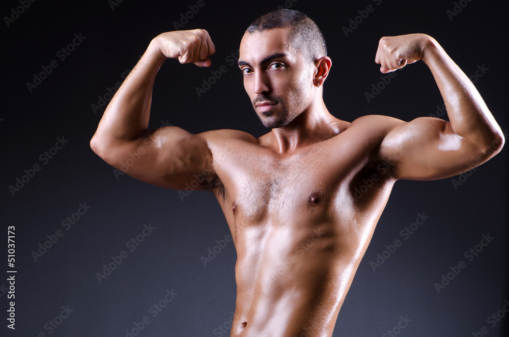 Muscular man in dark studio