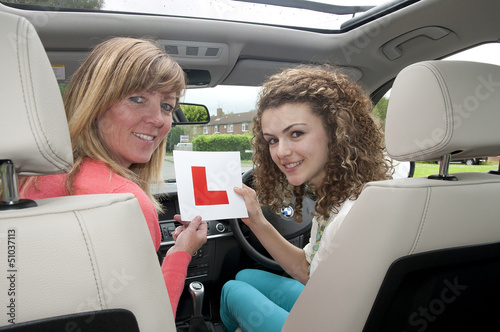Female driver holding L learner plate with instructor © petert2