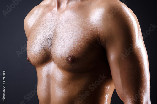 Muscular man in dark studio