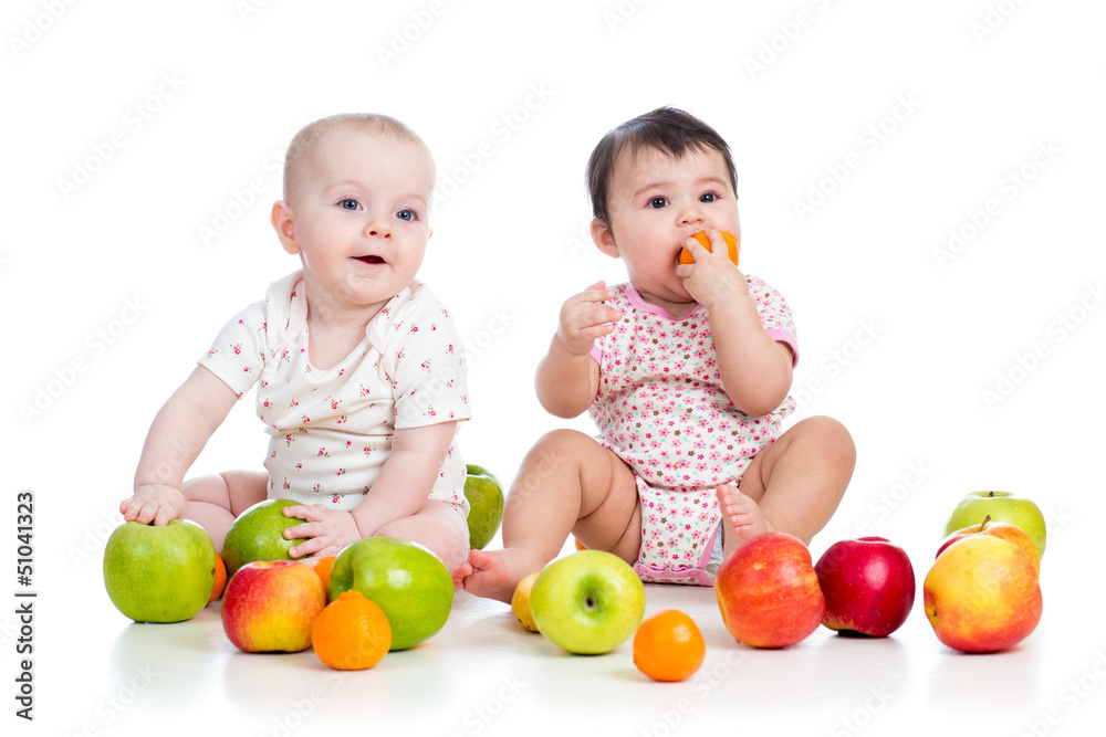 Funny kids babies eating healthy food fruits isolated on white Funny kids babies eating healthy food fruits isolated on white