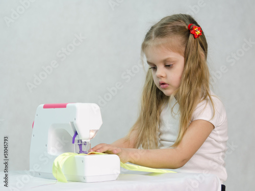 Девочка шьет на швейной машинке