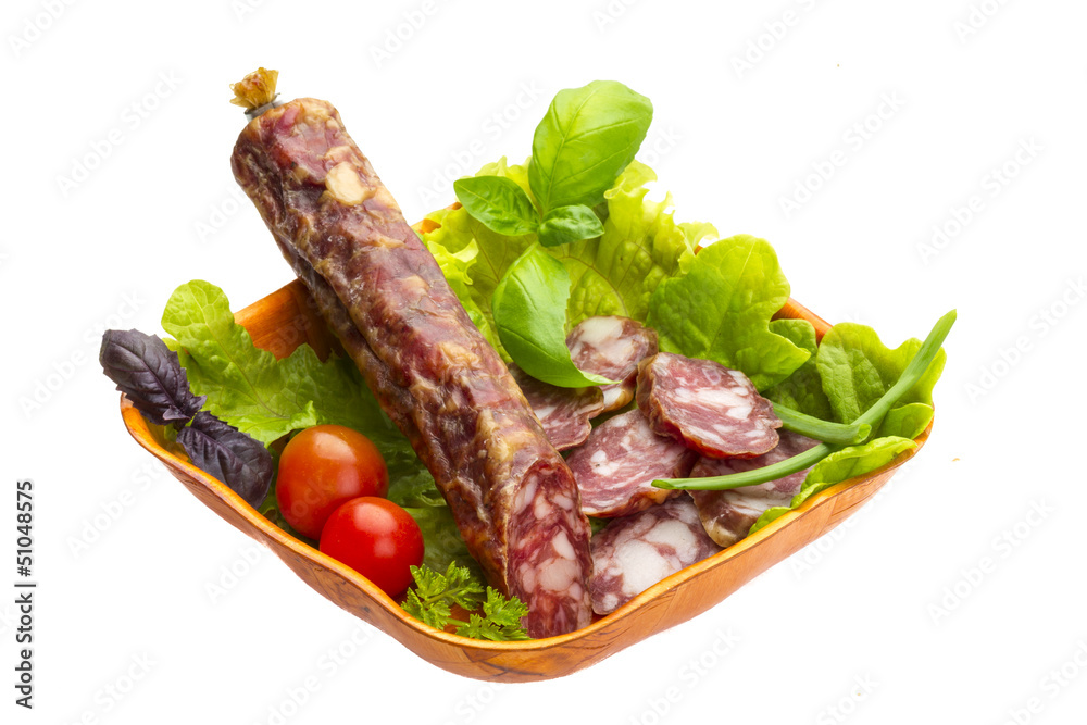Ripe salami with salad, basil, onion and tomato
