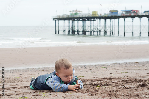 Obraz na płótnie Child on beach with pier, Devon, England