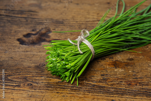 a bunch of fresh chives on a wooden table
