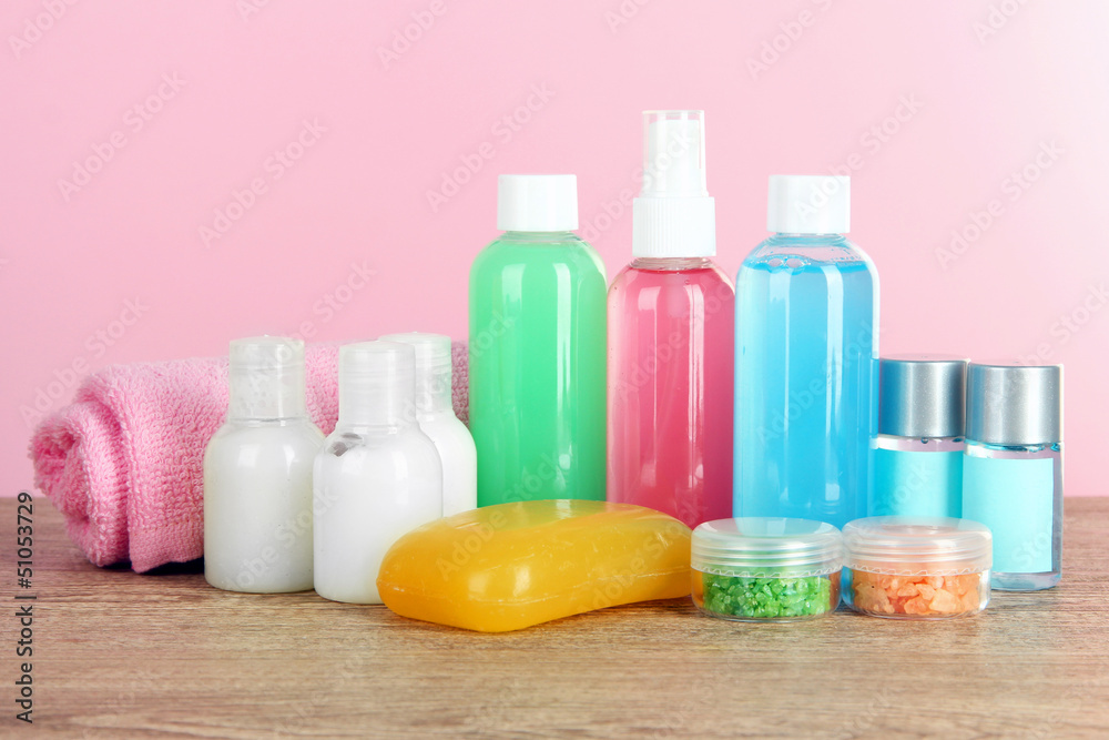 Hotel amenities kit on table on pink background Hotel amenities kit on table on pink background