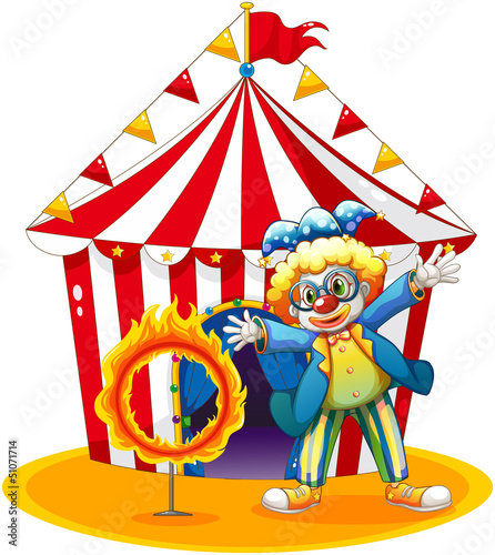 A circus tent at the back of the clown with a ring of fire