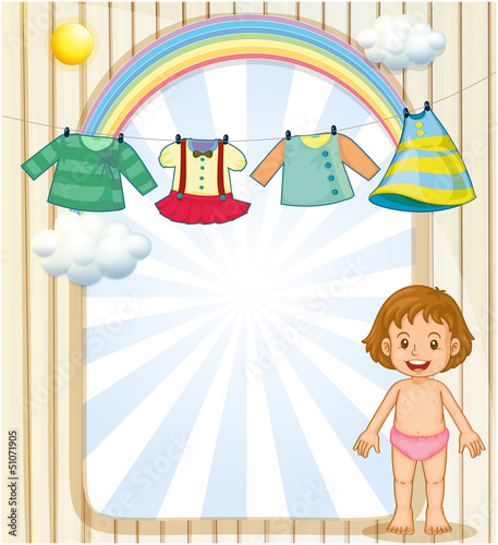 A baby below the hanging clothes