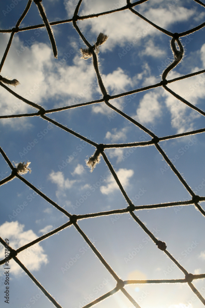 Zerrissenes Fussballnetz mit Blick in den Himmel Zerrissenes Fussballnetz mit Blick in den Himmel