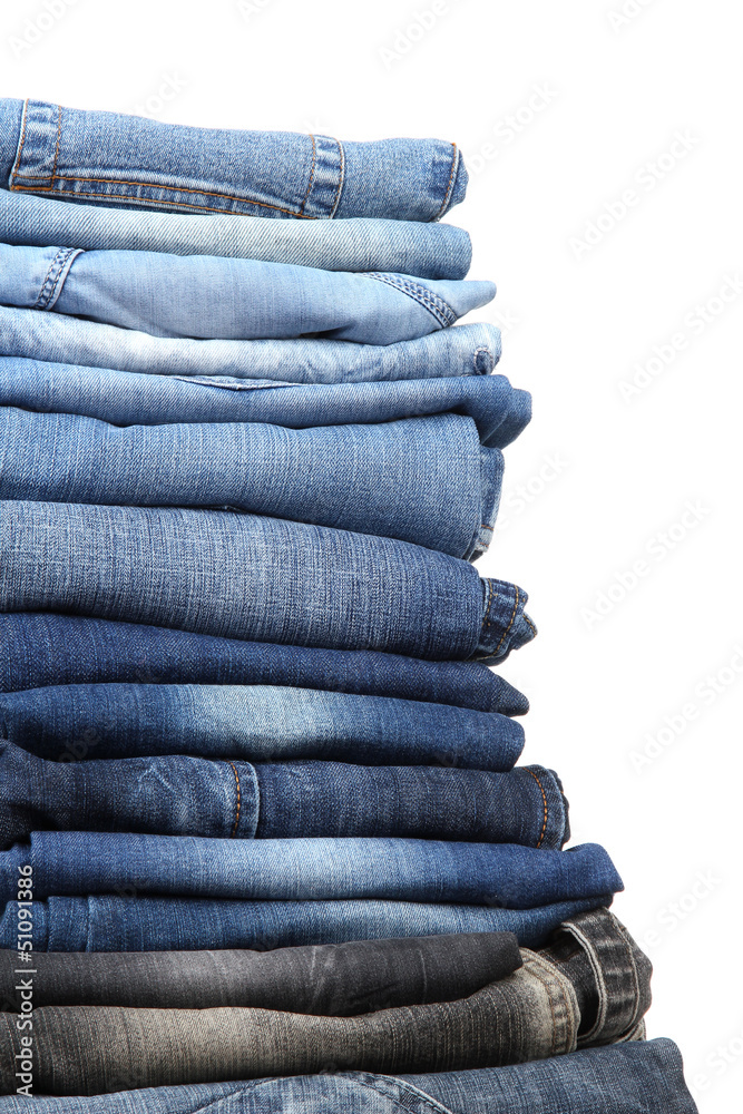 Many jeans stacked in a pile isolated on white Many jeans stacked in a pile isolated on white