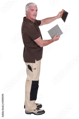 Man holding a tile and a spatula © auremar