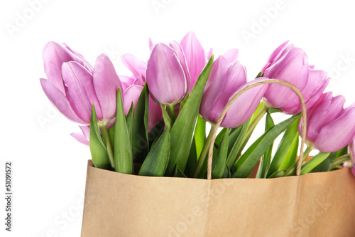 Fototapeta Naklejka Na Ścianę i Meble -  Beautiful bouquet of purple tulips in paper bag, isolated