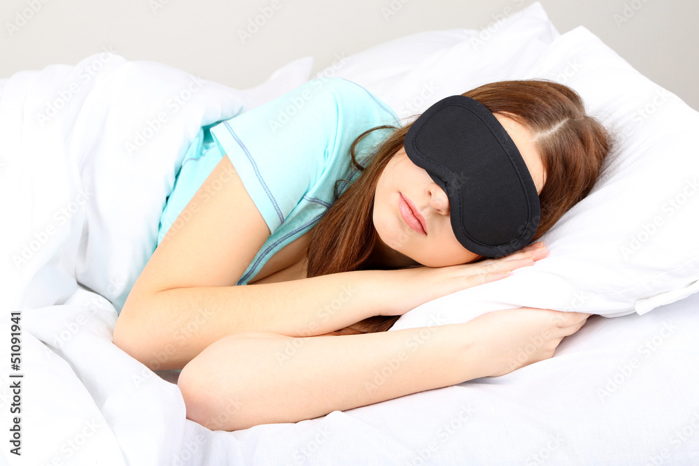 Beautiful young woman sleeping in bed with eye mask Beautiful young woman sleeping in bed with eye mask