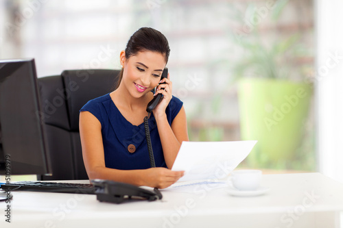 young businesswoman on the telephone and reading report