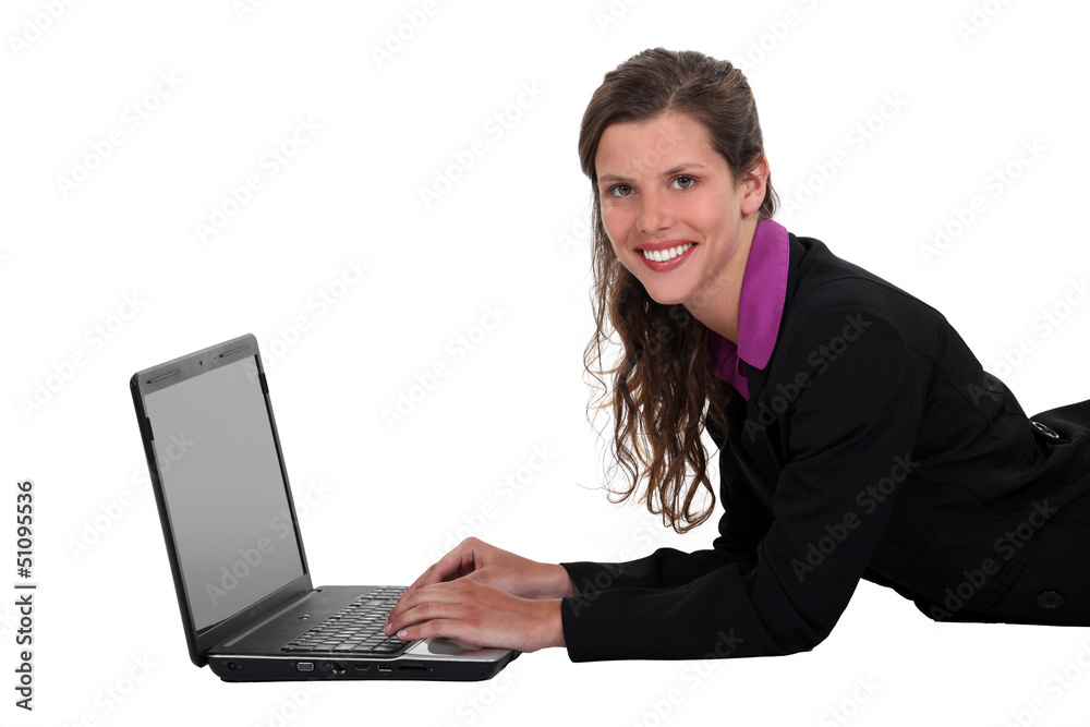 Businesswoman laying on the floor with her laptop. Businesswoman laying on the floor with her laptop.