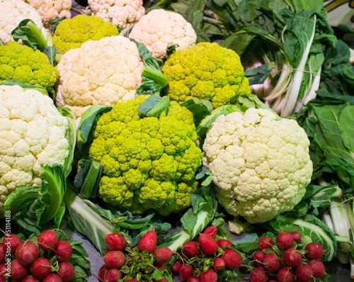 Choice of cauliflowers and bunches of radish on market