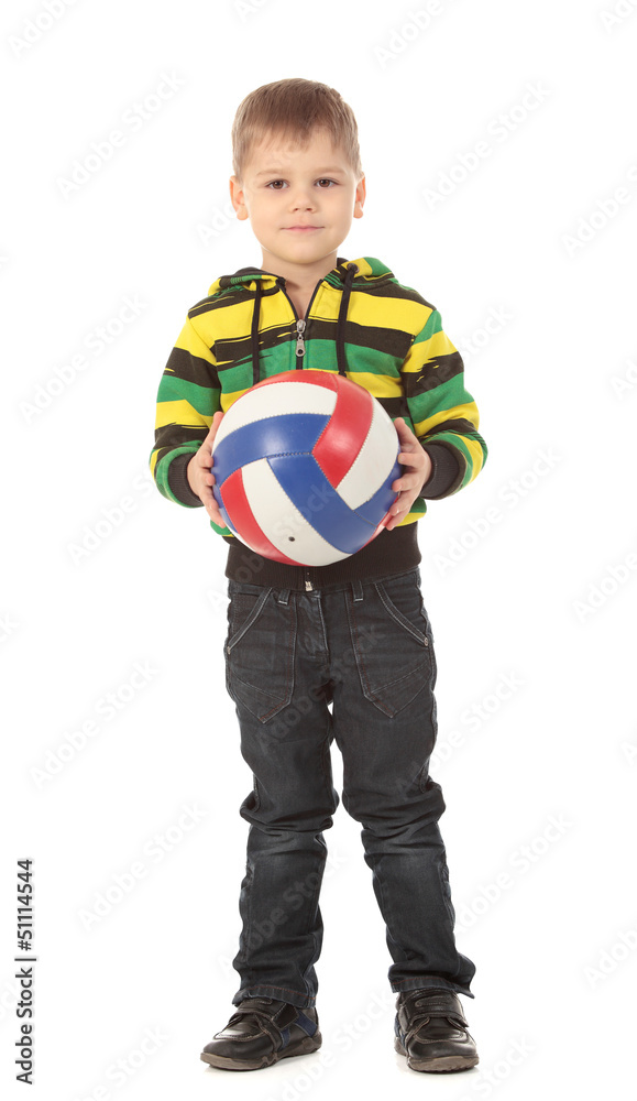 The cute little boy holds a volleyball ball and smiles The cute little boy holds a volleyball ball and smiles
