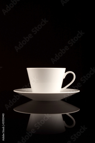 White coffee cup on black reflective surface