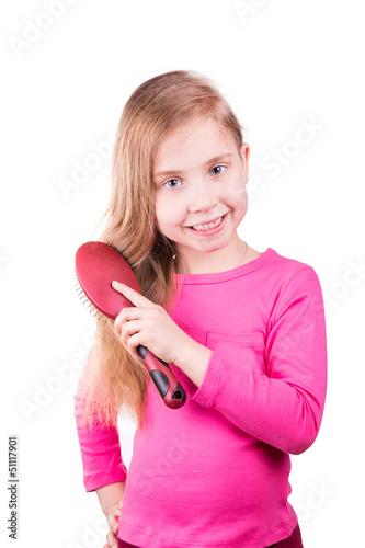 Beautiful little girl brushing her long hair.