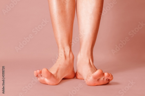 Healthy female feet with splayed fingers on pink background