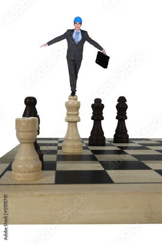 Architect balancing in chess piece