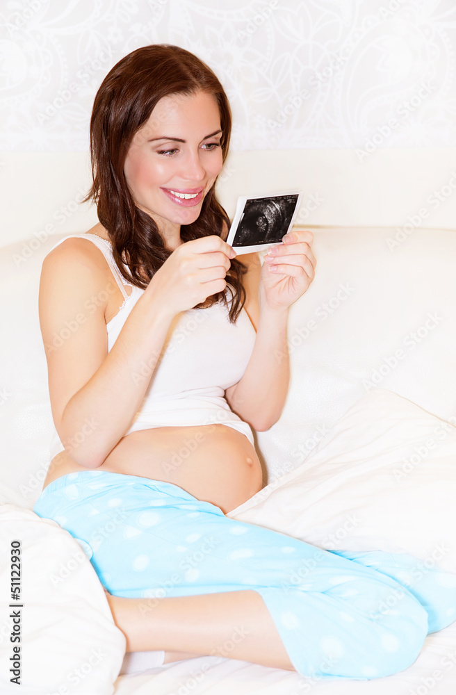 Pregnant girl looking on sonogram picture