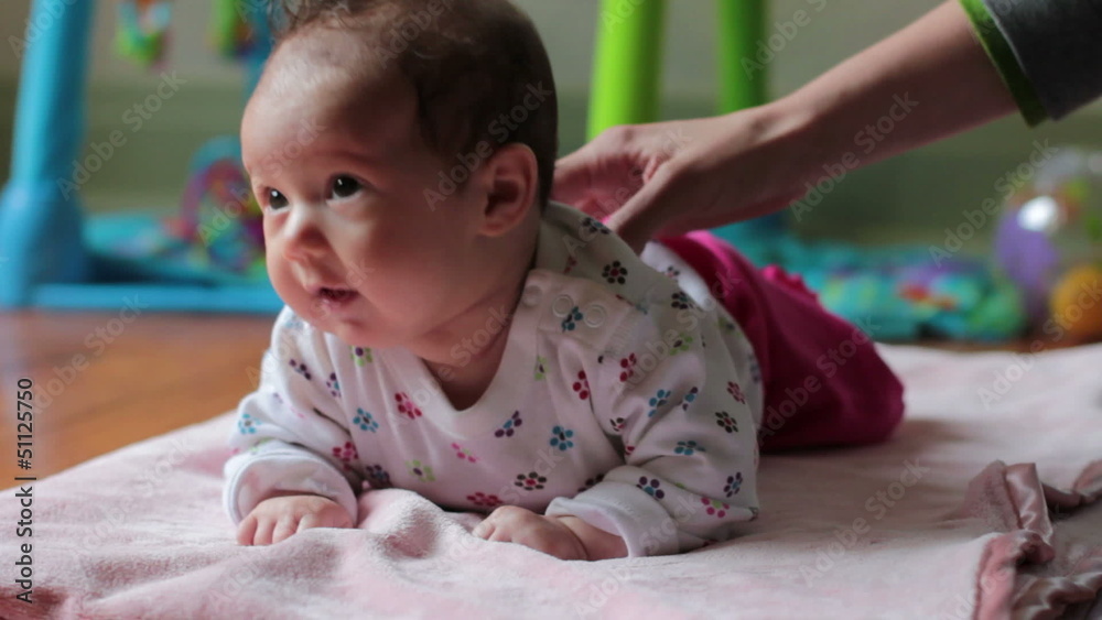 Happy baby lying on her stomach, dolly shot Happy baby lying on her stomach, dolly shot