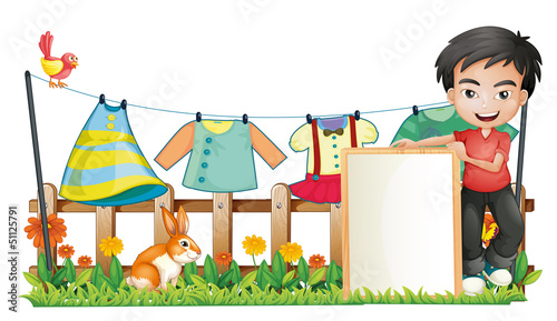 A boy with a frame in front of the hanging clothes
