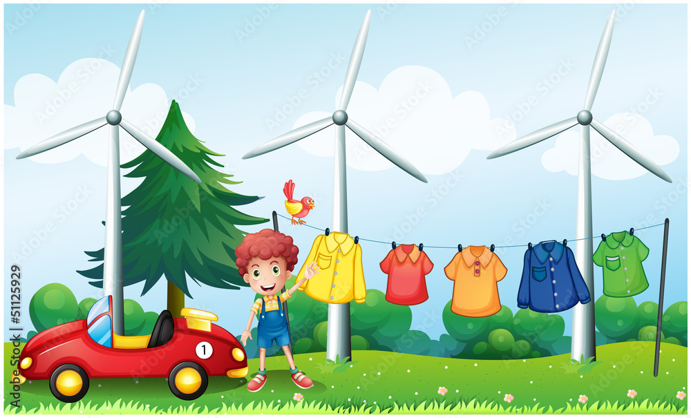 Obraz premium A boy in the garden with his car and hanging clothes