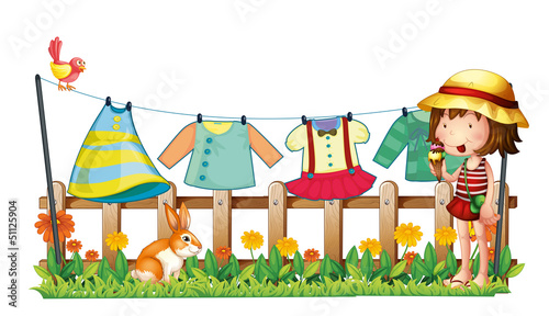 A girl with icecream near the hanging clothes