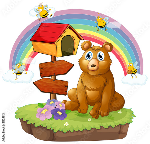 A bear beside a wooden mailbox and a wooden signboard