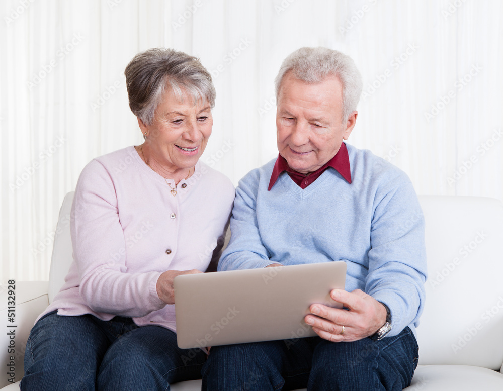 Senior Couple Looking At Laptop Computer Senior Couple Looking At Laptop Computer