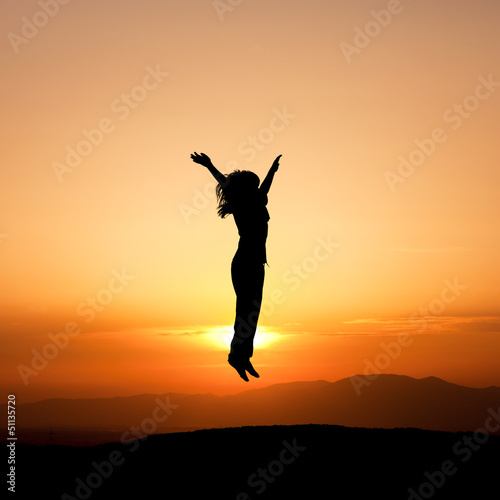 silhouette of child jumping in sunset