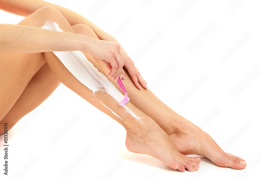 Beautiful woman is shaving her leg, isolated on white Beautiful woman is shaving her leg, isolated on white