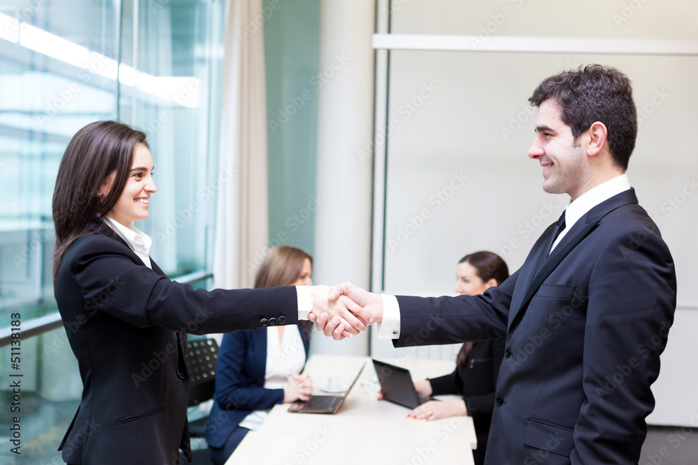 Business people shaking hands in the office, finishing a meeting Business people shaking hands in the office, finishing a meeting
