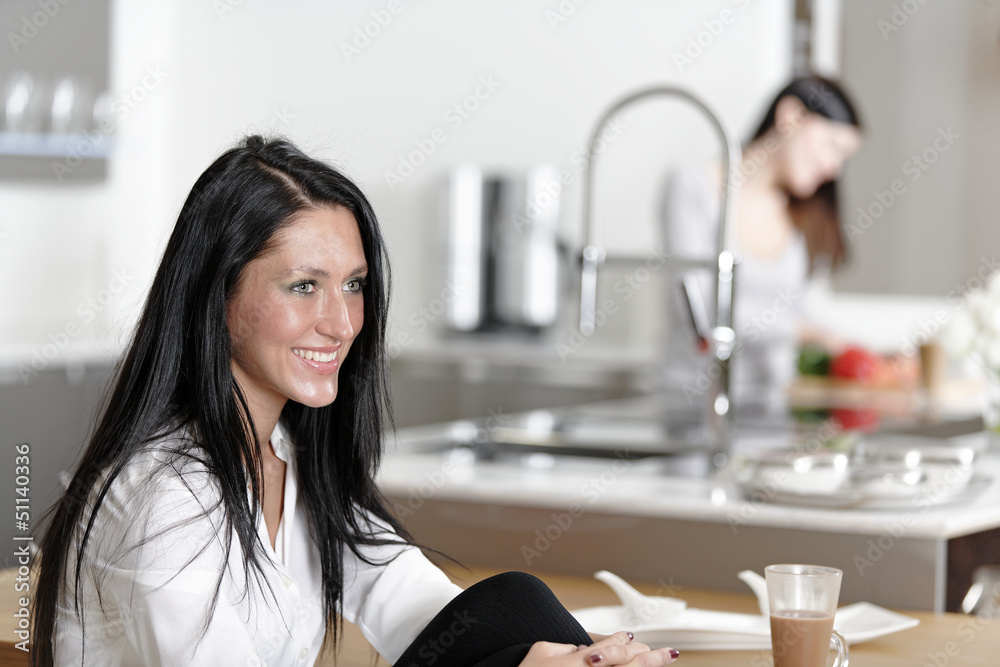 Two friends catching up in the kitchen Two friends catching up in the kitchen