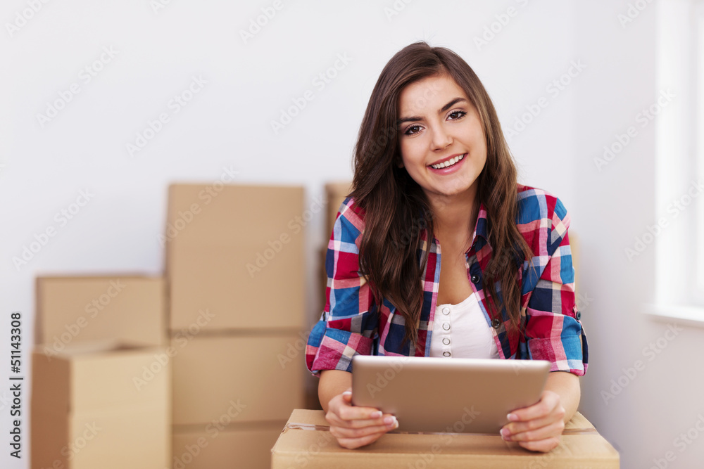 Young woman using digital tablet during moving in new apartment Young woman using digital tablet during moving in new apartment