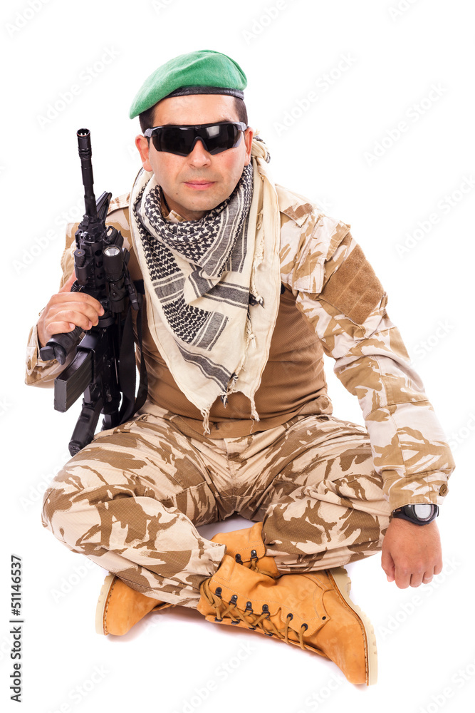 Fototapeta premium Young soldier with beret and glasses holding an automatic