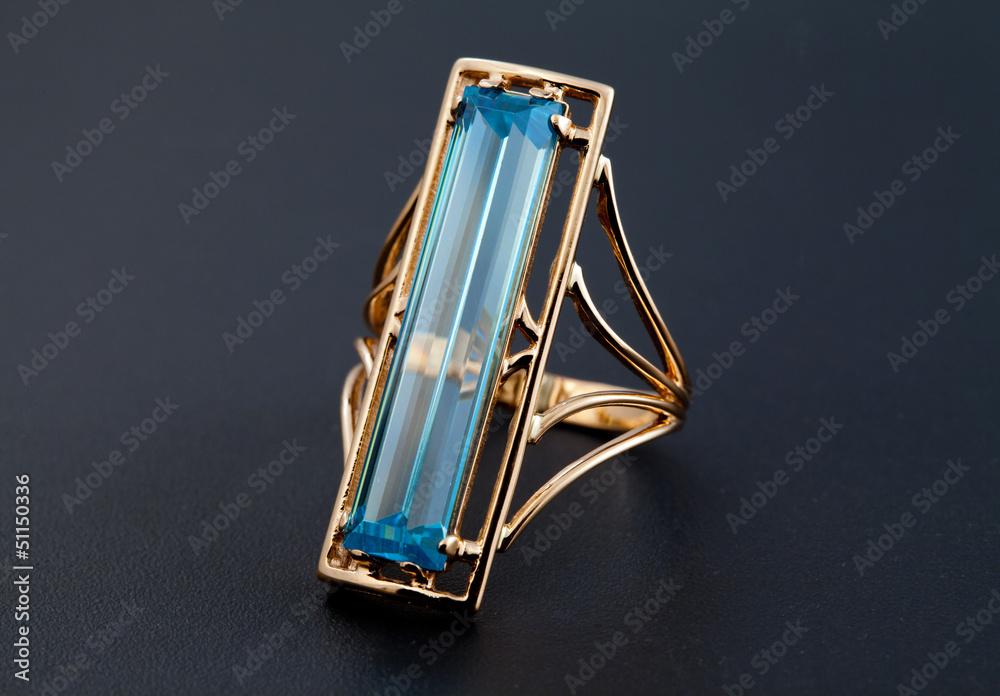Obraz premium Golden jewelry ring with blue topaz