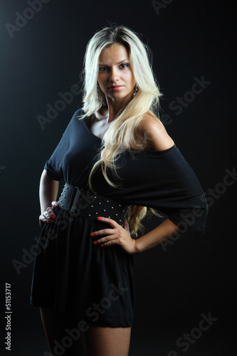 Beautiful woman in sexy evening dress against dark background