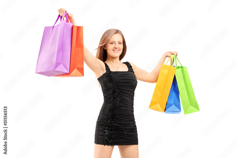 Young smiling woman in black dress holding shopping bags